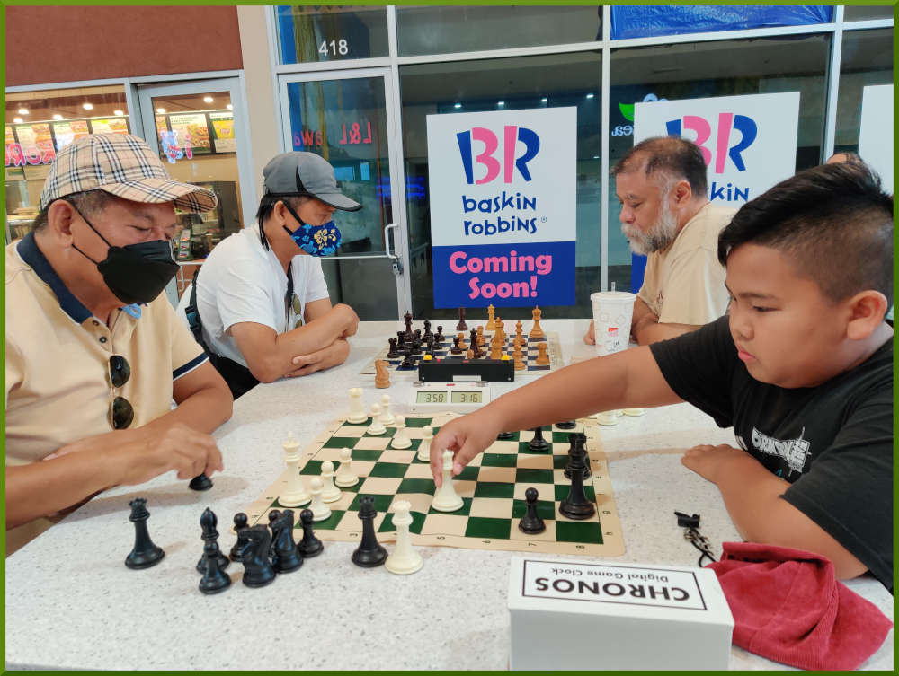 May 31st, 2022. Ka Makana Alii chess meetup. Ceasar vs young boy (near board). Edgar vs Chet (far board).
