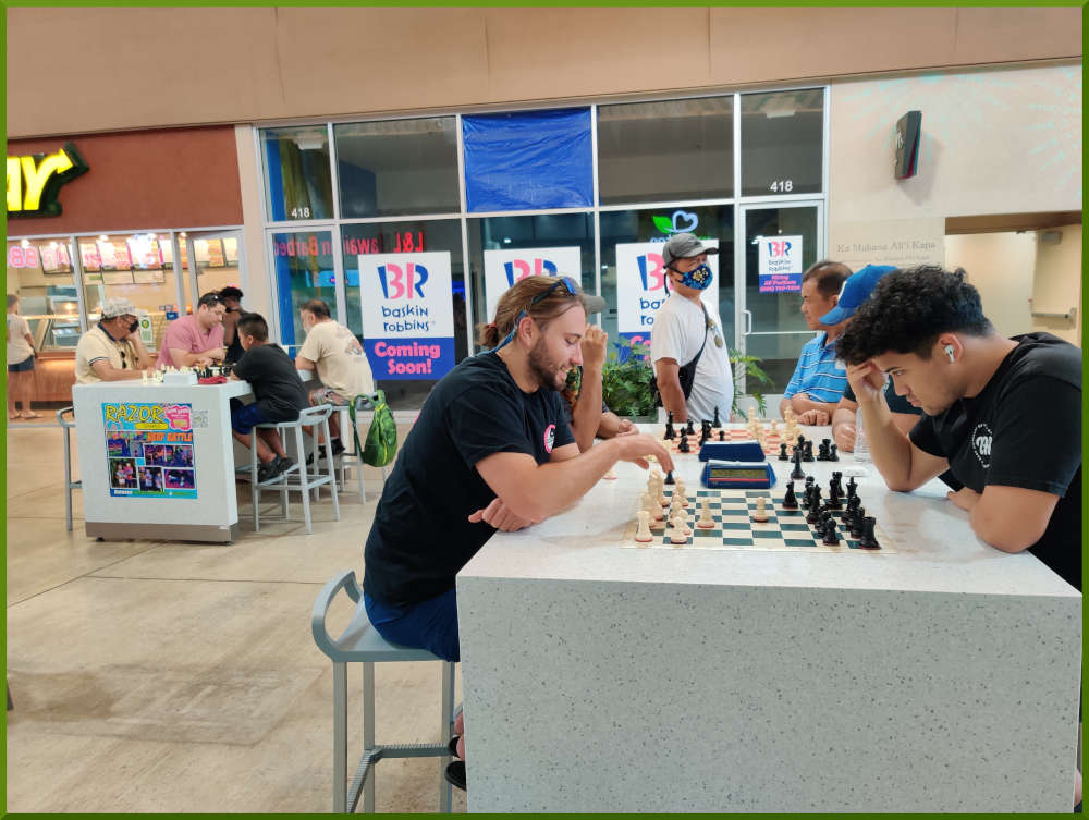 May 31st, 2022. Ka Makana Alii chess meetup. Ari vs Christian, Jeremy vs Ceazar (near table). Ceasar vs young boy, Phil vs Chet (far table).