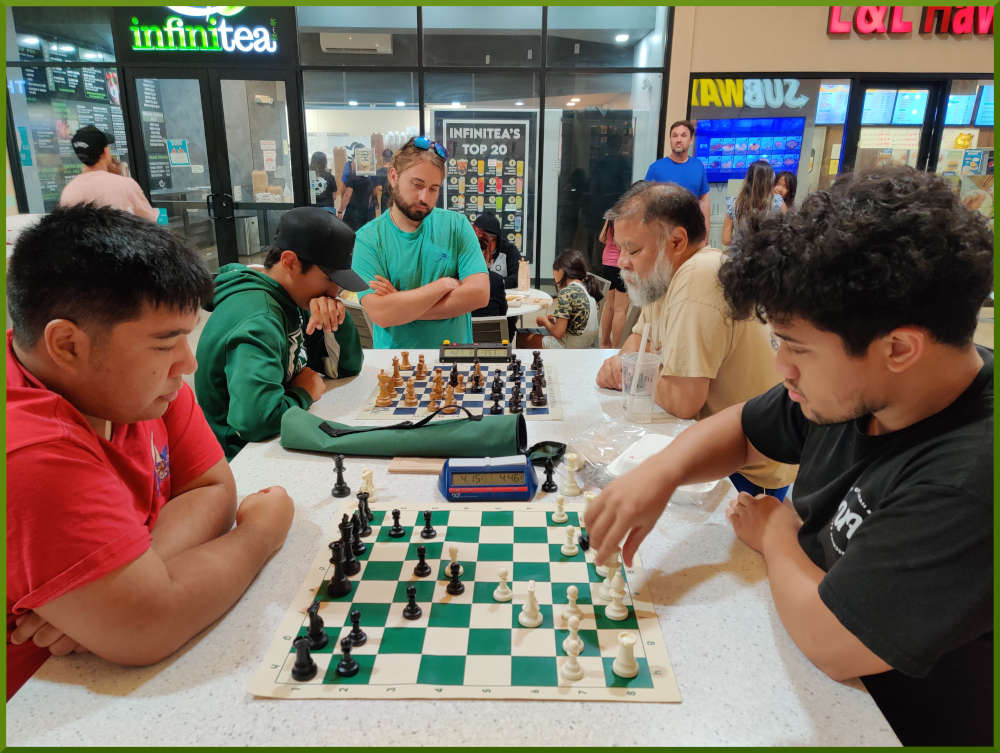 June 21st, 2022. Ka Makana Alii chess meetup. Ceazar vs Christian (near board). Little Benny vs Chet (far board).