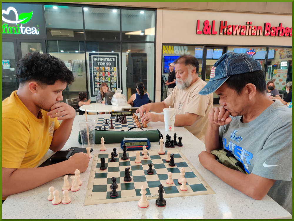 July 5th, 2022. Ka Makana Alii chess meetup. Christian vs Eddie (near board). Chet waiting for a challeger (far board).